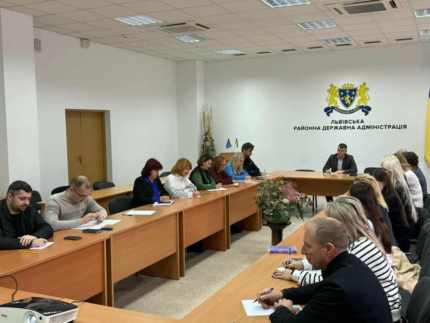 фото людей за столами, позаду герб Львівського району та напис "ЛЬВІВСЬКА РАЙОННА ДЕРЖАВНА АДМІНІСТРАЦІЯ"