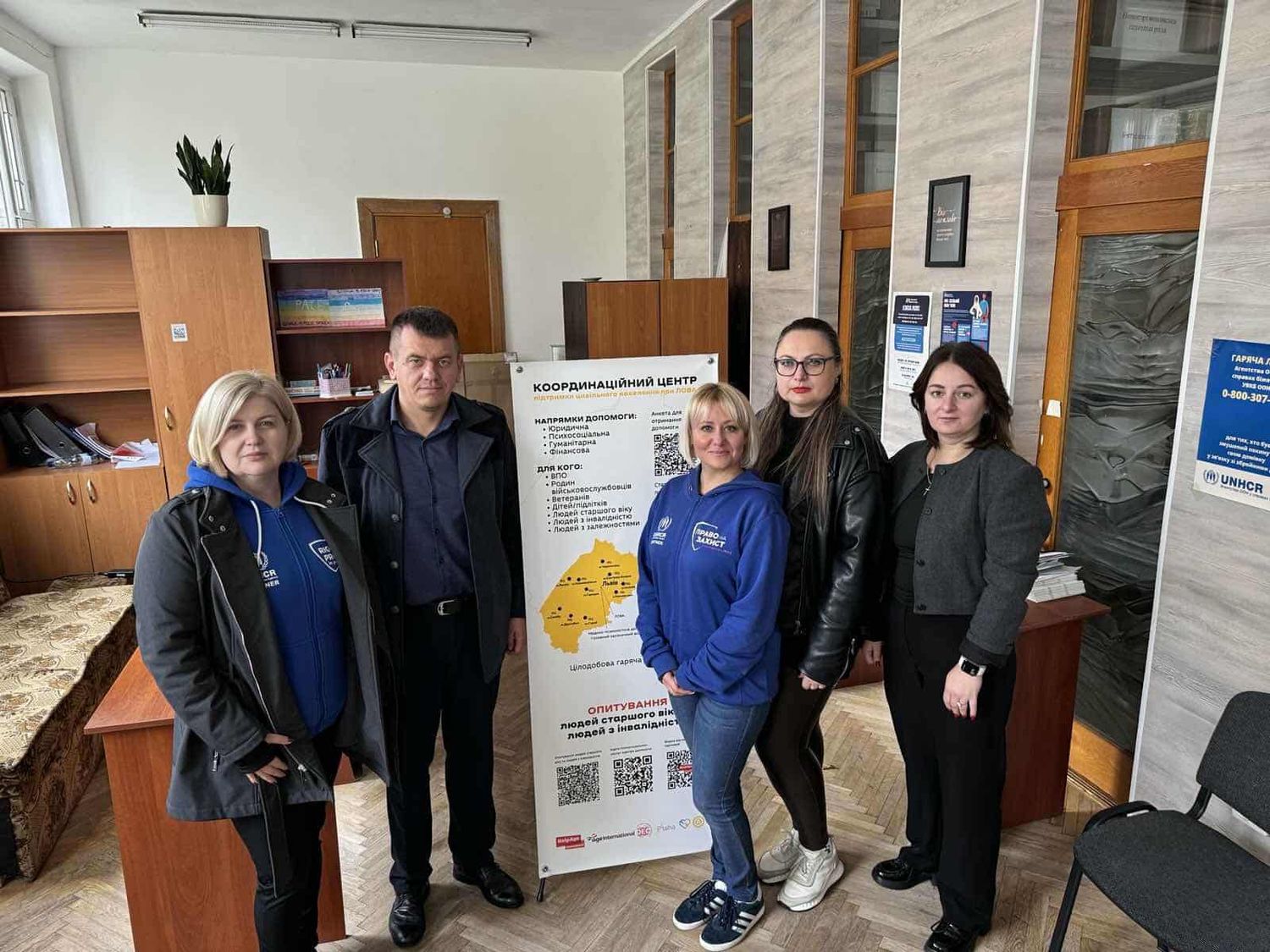 люди стоять в кабінеті біля х-банера