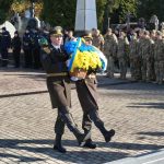 військовослужбовці несуть синьо-жовтий букет, на фоні стоїть юрба людей