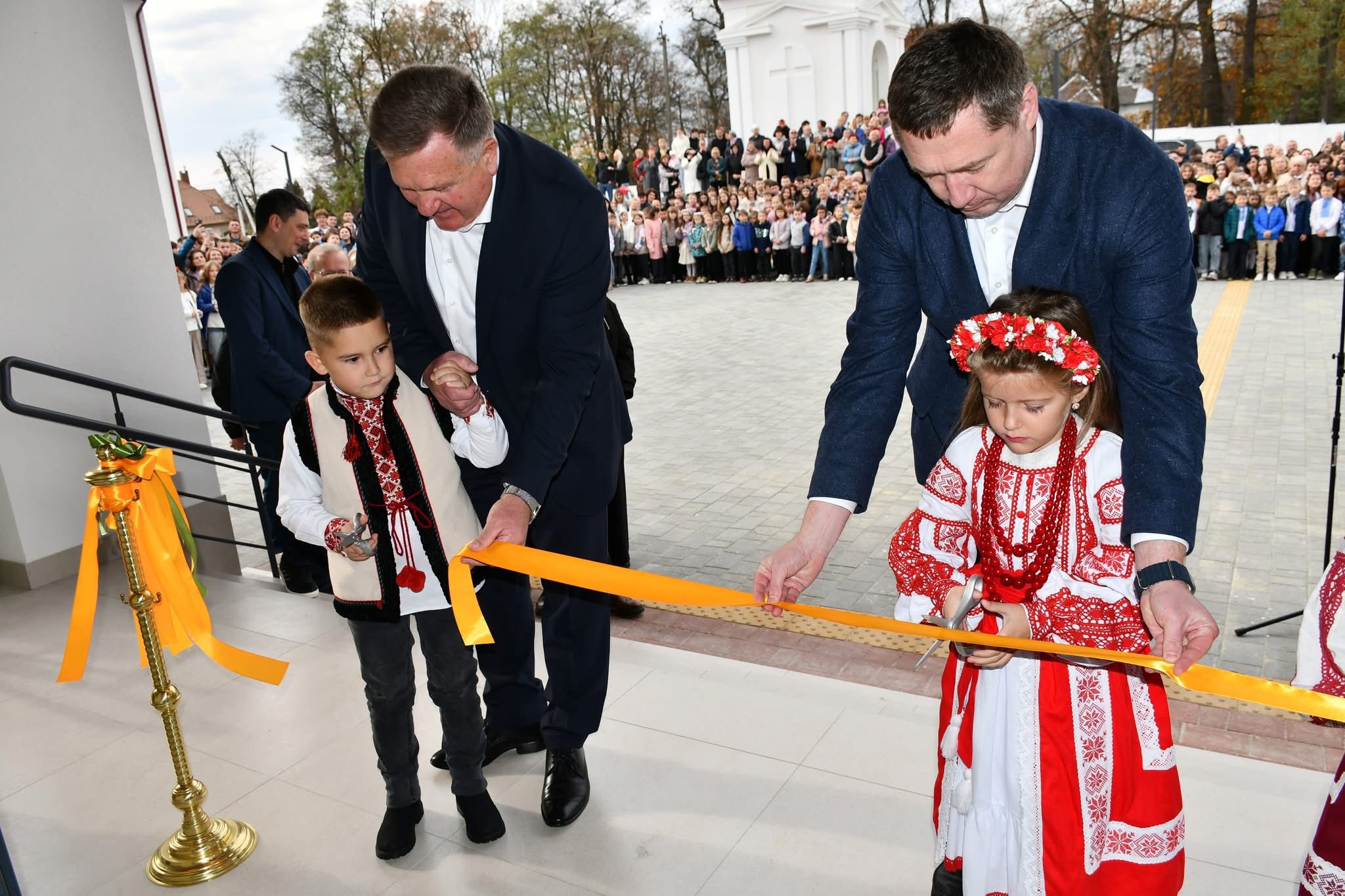 люди перерізають стрічку перед входом