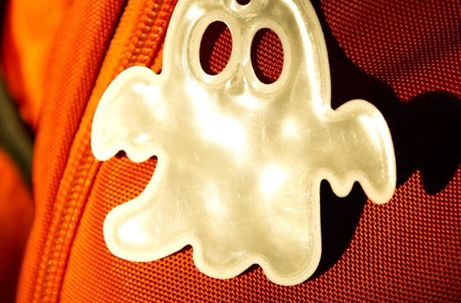 флікер у вигляді привида, прикріплений до рюкзака цегляного кольору