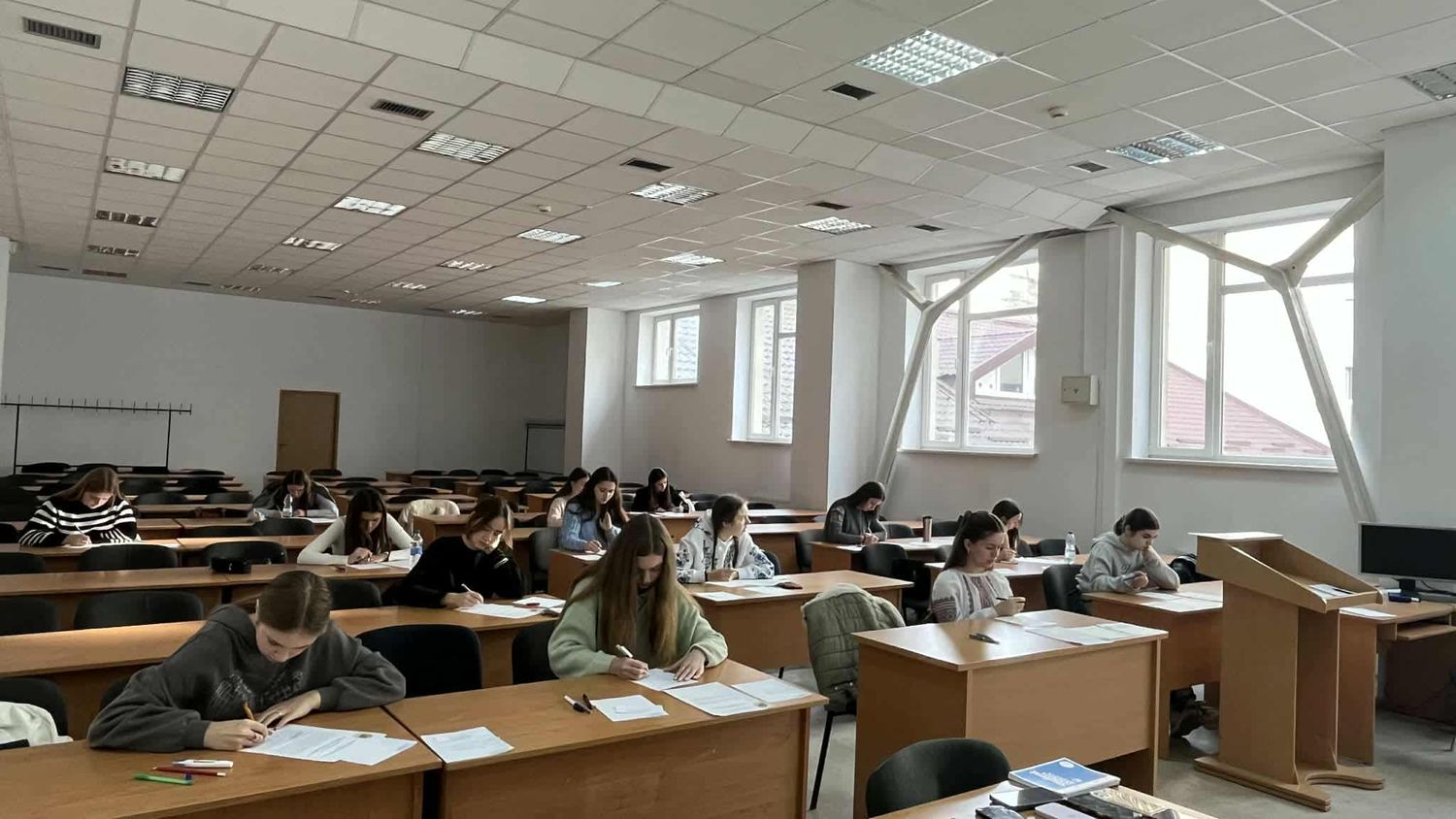 учні сидять в аудиторії за партами та пишуть