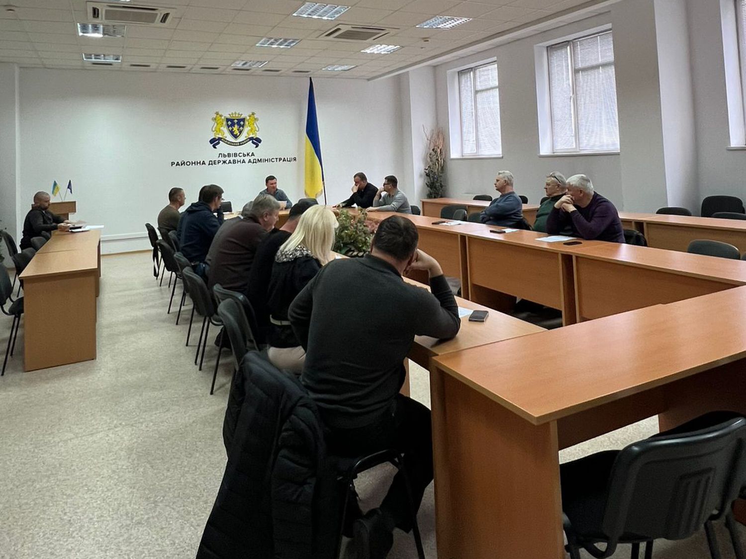 люди сидять за столом в залі