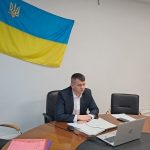 людина сидить в кабінеті під прапором