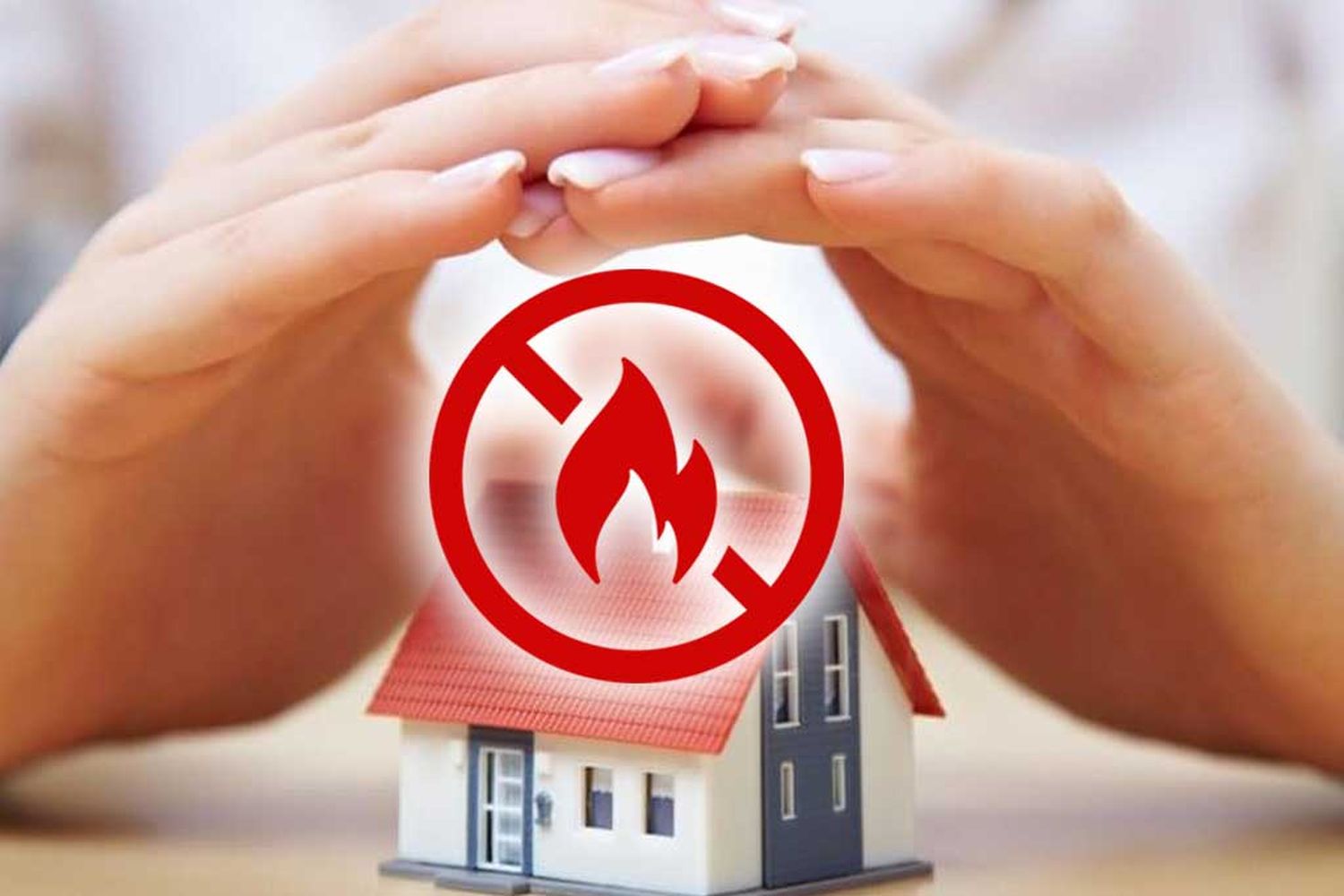 іграшковий будиночок під руками людини, червоний знак заборони та іконка вогника