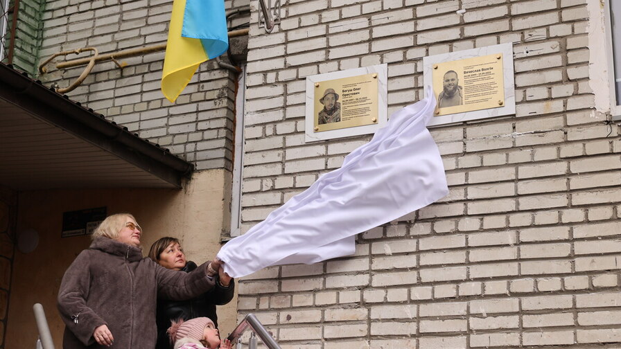 з меморіальних табличок на стіні знімають полотно