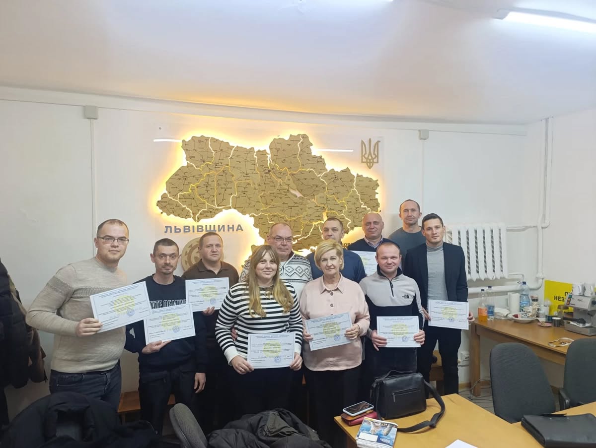 люди з сертифікатами біля великої карти