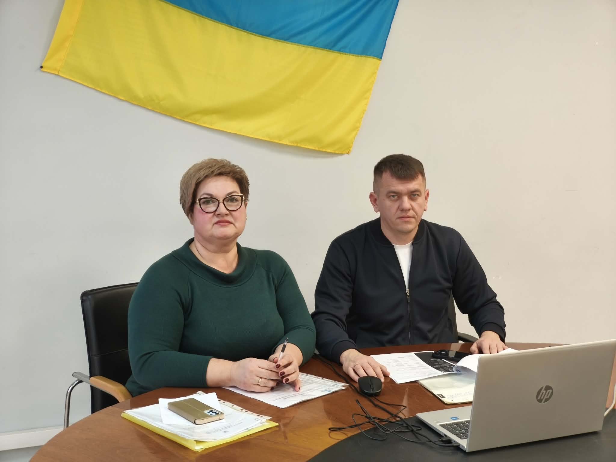 двоє людей сидять під українським прапором