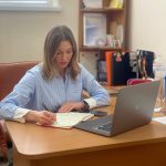 людина сидить за ноутбуком
