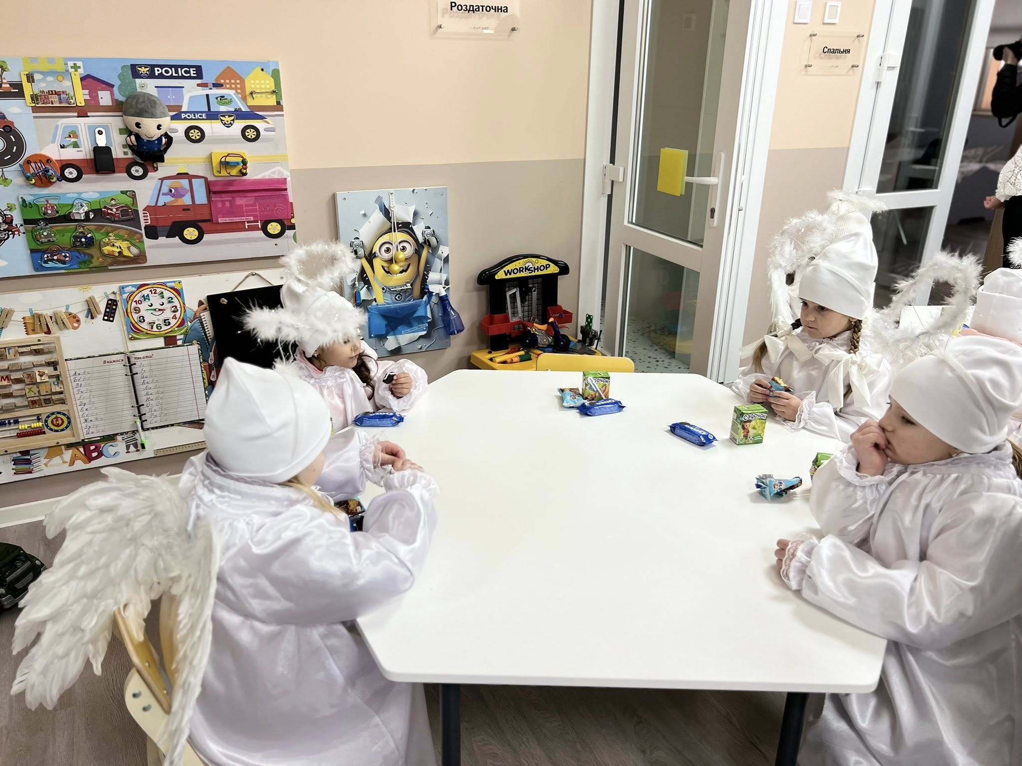 діти сидять за столиком