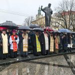священнослужителі під парасолями