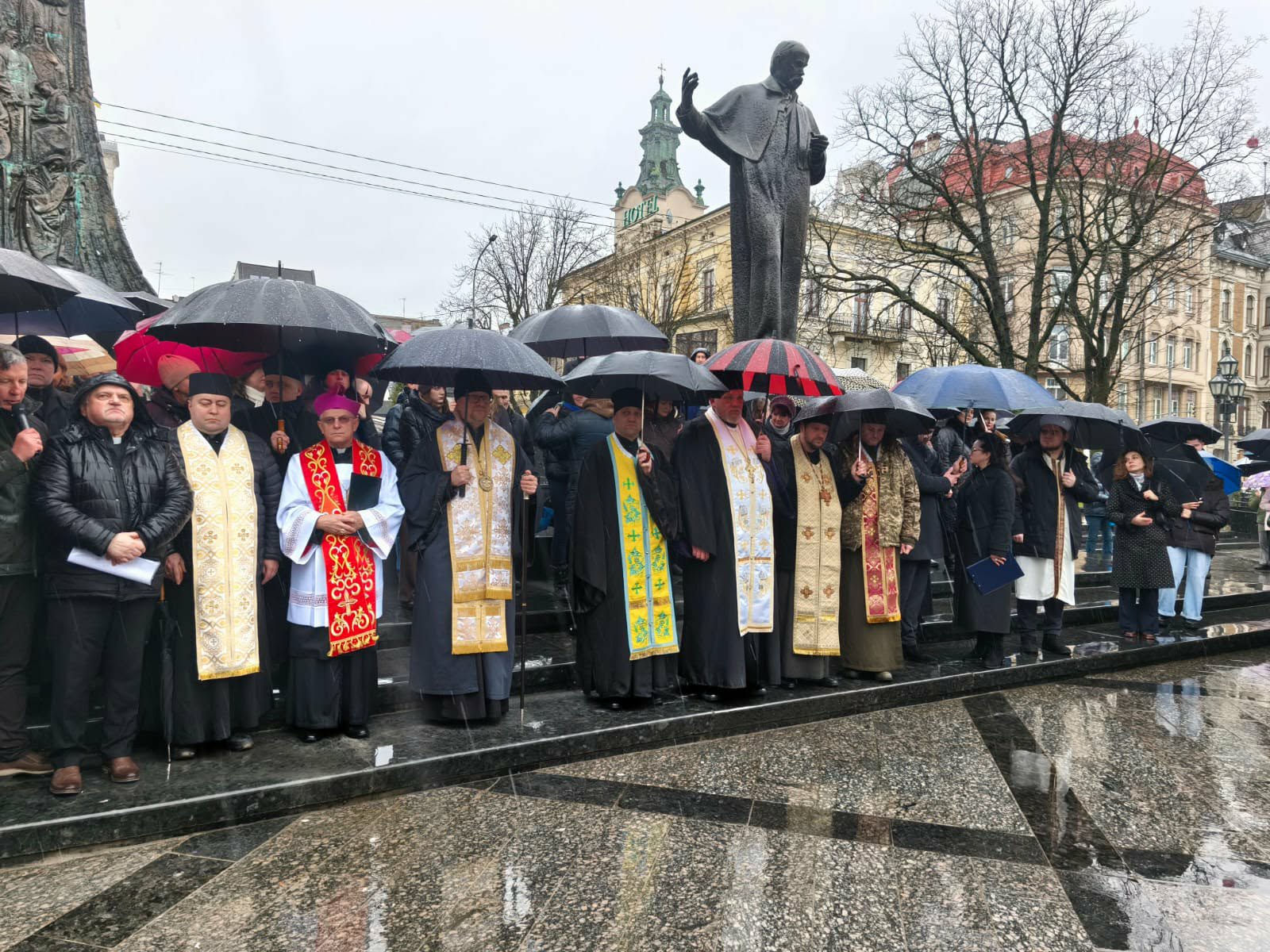 священнослужителі під парасолями